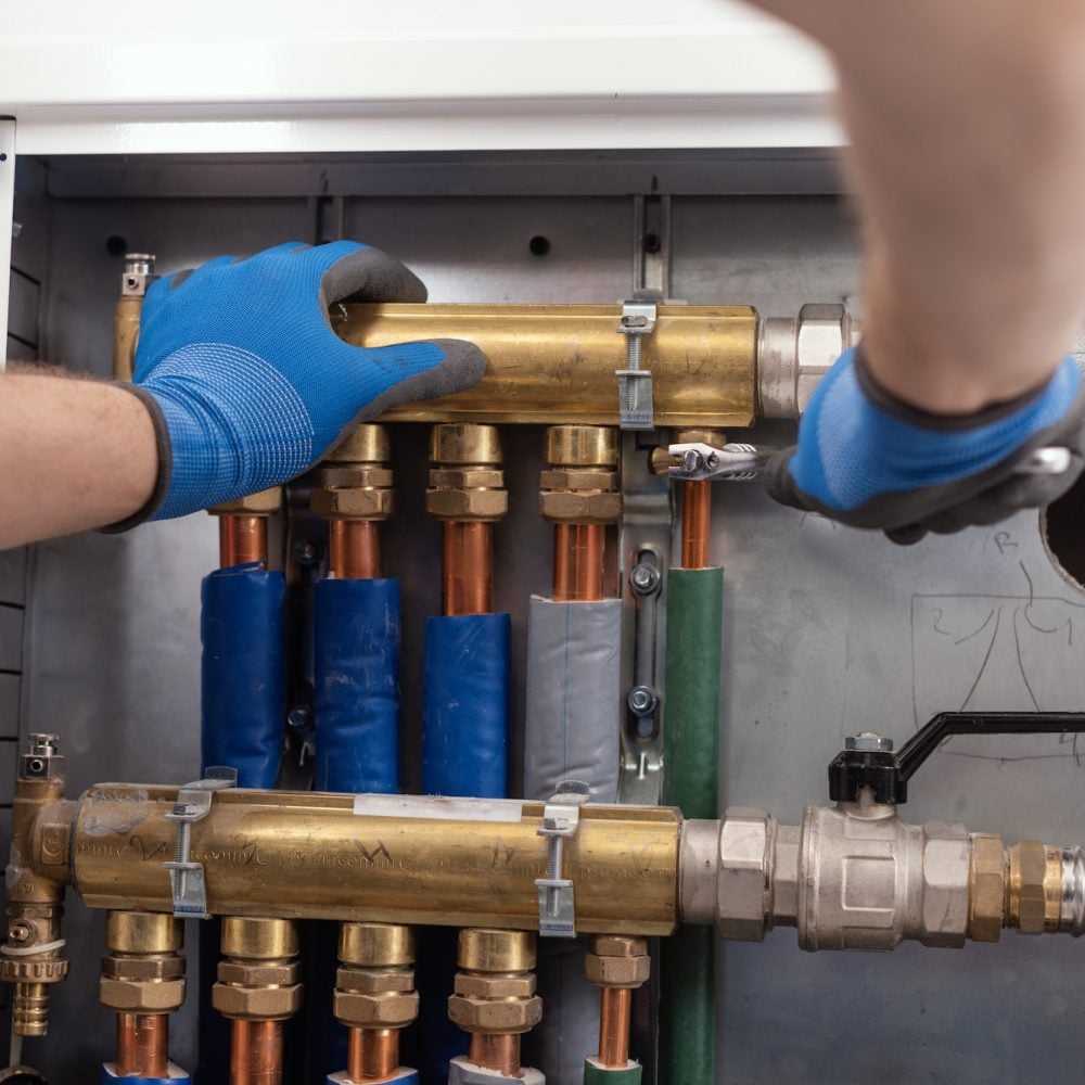 Plumber installing plumbing manifolds with shutoff valves